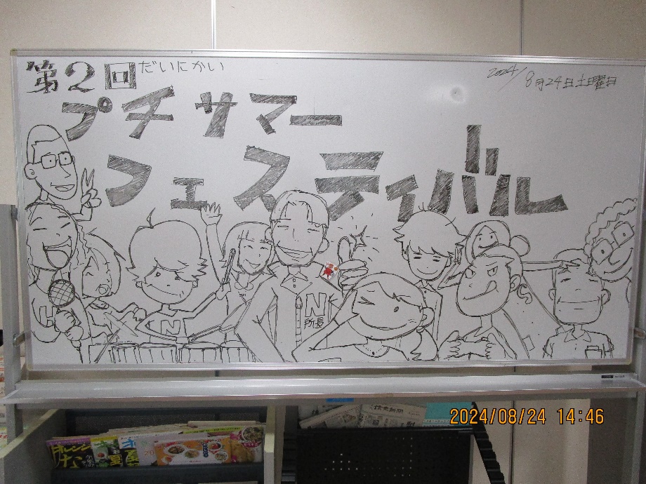 ホワイトボードには「2回プチサマーフェスティバル」という太文字が書かれ、その下には利用者と職員のかわいい似顔絵イラストが描かれている。