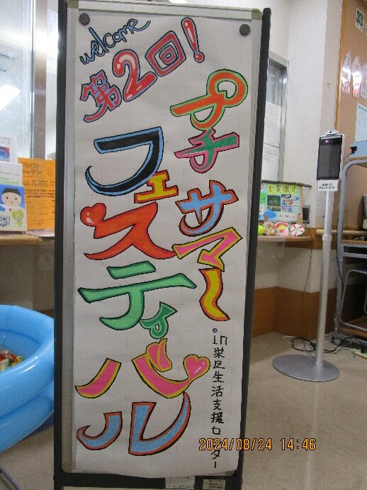 看板には「2回プチサマーフェスティバル」という文字がカラフルな色で表現されている。