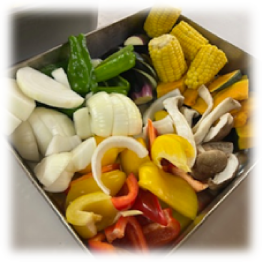 トレーには、トウモロコシやピーマン、トマトなどの野菜が入っています。
