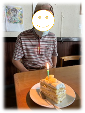 ケーキには火の灯った一本のロウソクが立てられ、最年長の方の誕生日を祝っています。