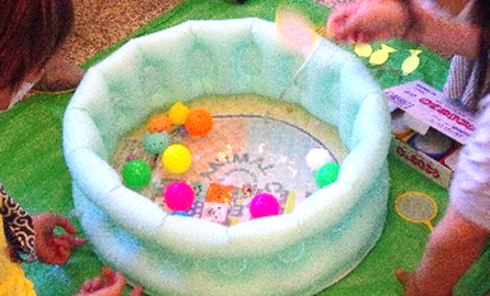 水が入った子供用プールには色とりどりのスーパーボールが浮かんでいます。
