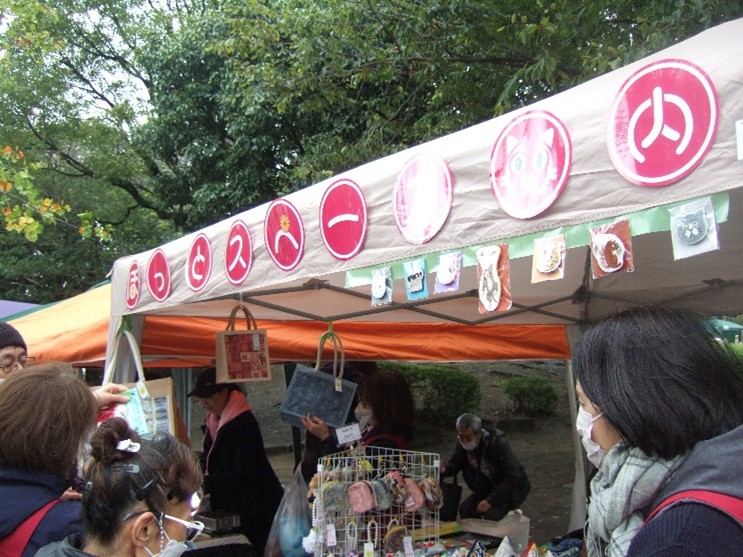 メンバーがテント周辺で販売準備を進めています。