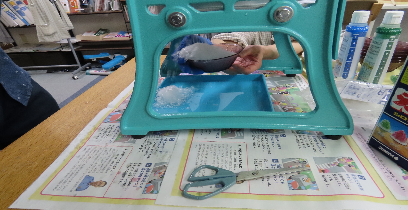 かき氷機で削った氷を器に入れています。